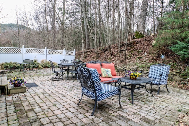 view of patio with outdoor dining space, an outdoor living space, and fence