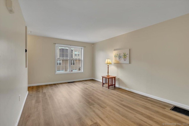 unfurnished room with light wood finished floors and baseboards