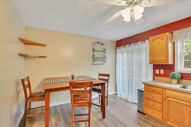 dining area with light wood finished floors, ceiling fan, and baseboards