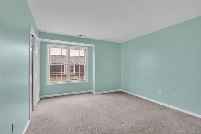 empty room featuring carpet flooring and baseboards