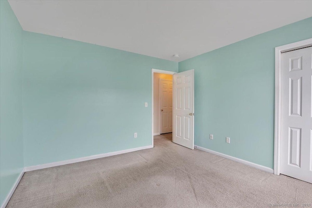 unfurnished bedroom featuring carpet flooring and baseboards