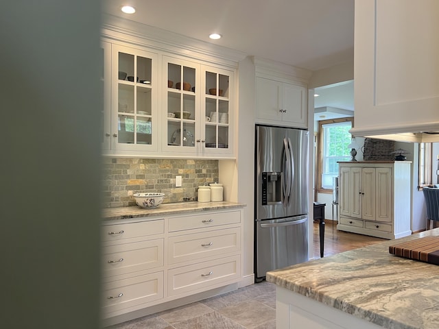 kitchen with stainless steel fridge, backsplash, glass insert cabinets, white cabinetry, and recessed lighting
