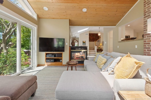 living area featuring wood ceiling, stairs, high vaulted ceiling, and a multi sided fireplace