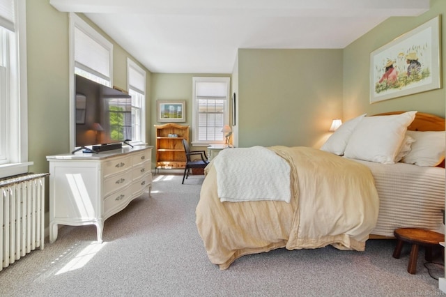 bedroom featuring radiator and light carpet