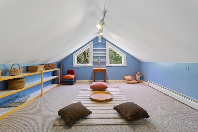 recreation room with rail lighting, carpet flooring, a baseboard heating unit, vaulted ceiling, and baseboards