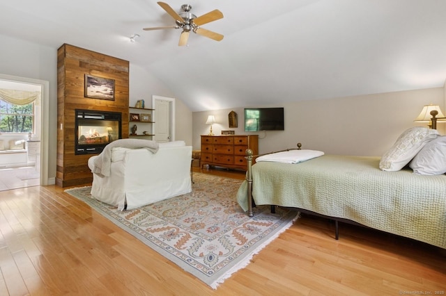 bedroom featuring light wood-style flooring, vaulted ceiling, and a ceiling fan