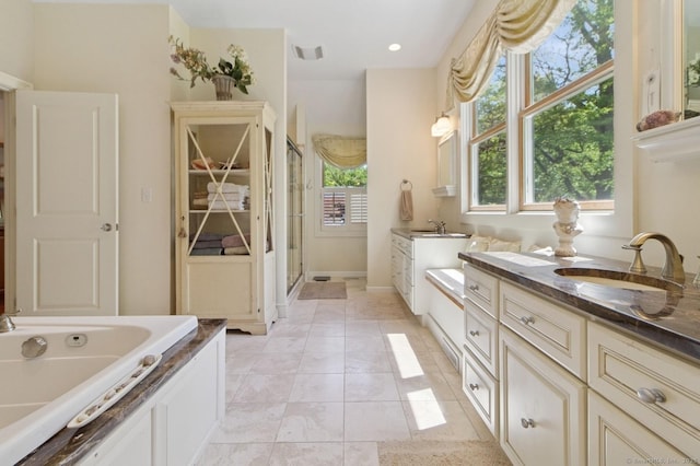 full bathroom featuring vanity, a stall shower, a garden tub, and tile patterned floors