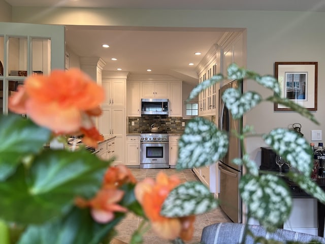 kitchen with stainless steel appliances, decorative backsplash, white cabinets, recessed lighting, and glass insert cabinets