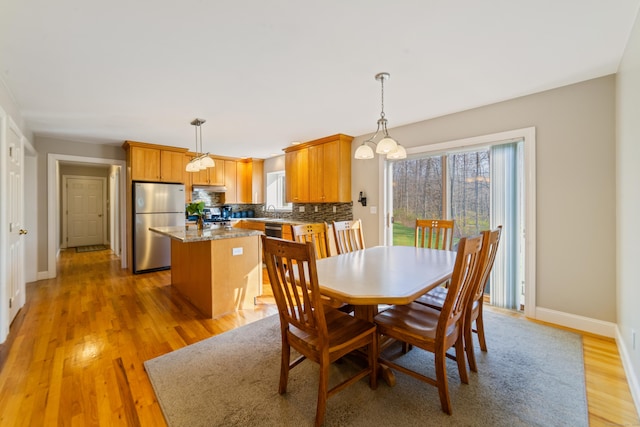 dining area featuring light wood-style floors and baseboards