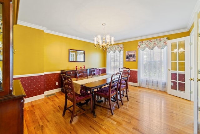 dining room featuring wainscoting, wood finished floors, a chandelier, and visible vents