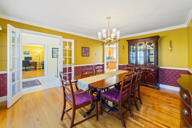 dining area featuring an inviting chandelier, light wood-style flooring, and french doors