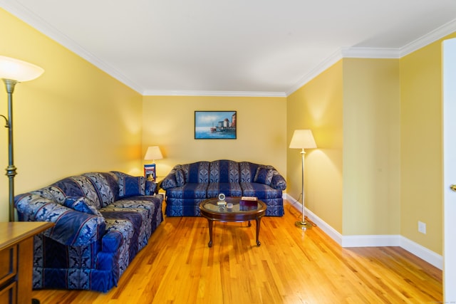 living room with baseboards, ornamental molding, and wood finished floors