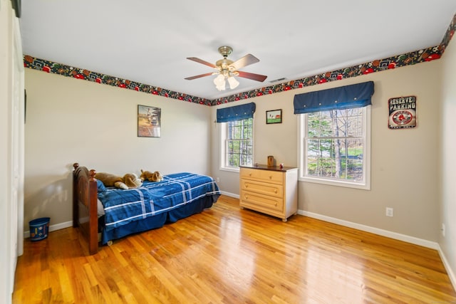 bedroom featuring baseboards, a ceiling fan, and light wood finished floors