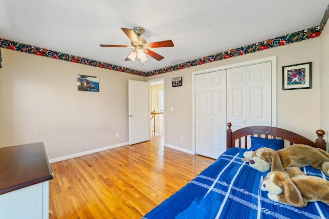 bedroom with light wood-style flooring, visible vents, baseboards, a ceiling fan, and a closet