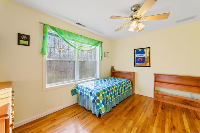 bedroom featuring wood finished floors, visible vents, baseboards, and ceiling fan