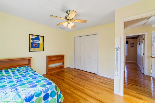 bedroom with light wood-style floors, a closet, and baseboards