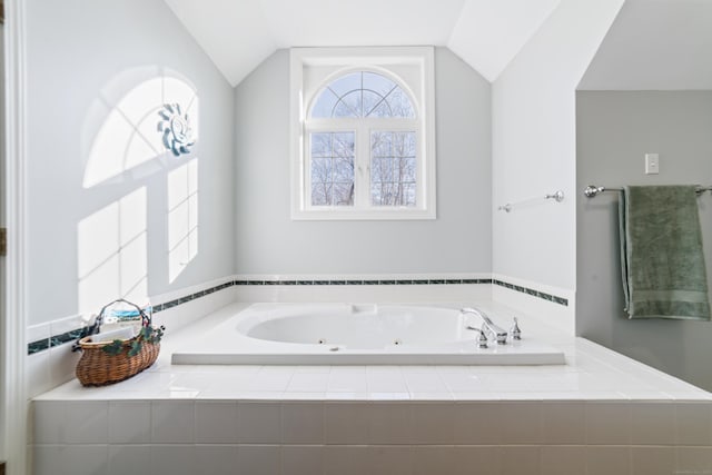 full bathroom with vaulted ceiling and a whirlpool tub