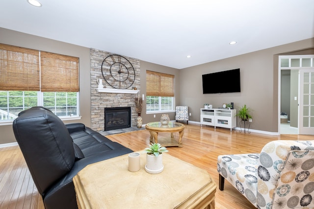 living area with baseboards, a healthy amount of sunlight, and wood finished floors
