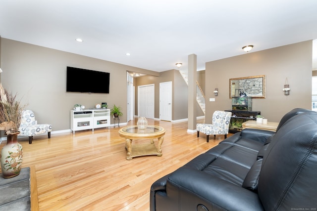living room featuring recessed lighting, stairway, baseboards, and wood finished floors