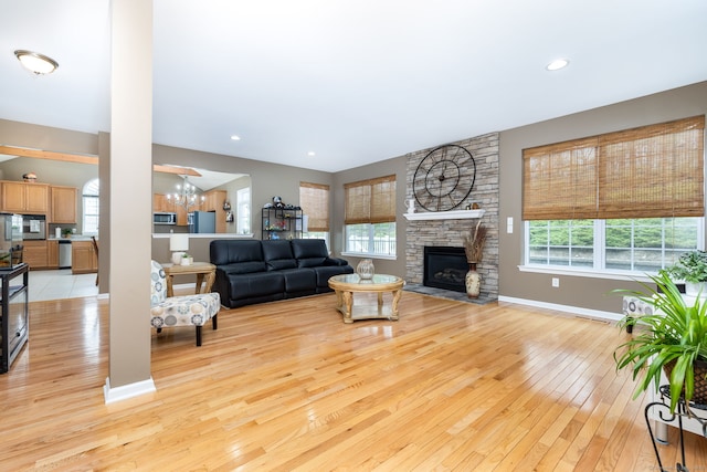 living area featuring baseboards, light wood-style floors, and plenty of natural light