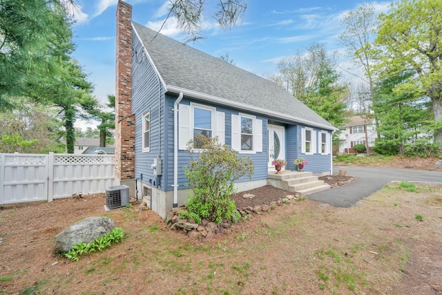 63 Rita Dr, Bristol, CT 06010 - view of front of home featuring a chimney, fence, roof with shingles, and central AC unit