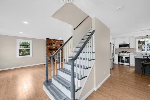 63 Rita Dr, Bristol, CT 06010 - stairway featuring healthy amount of natural light, wood finished floors, a chandelier, and recessed lighting