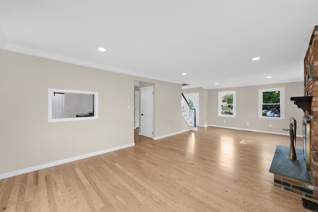 63 Rita Dr, Bristol, CT 06010 - unfurnished living room with stairs, a brick fireplace, light wood finished floors, recessed lighting, and baseboards