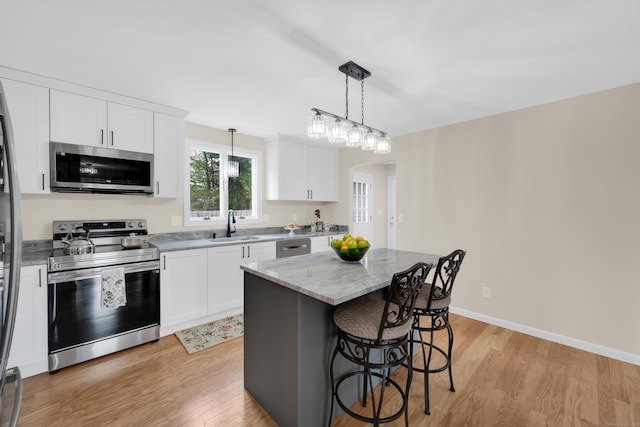 63 Rita Dr, Bristol, CT 06010 - kitchen featuring stainless steel appliances, a sink, a kitchen breakfast bar, and light wood-style flooring