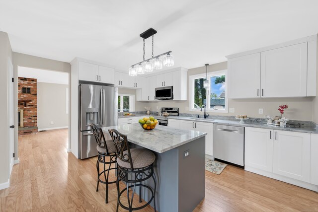 63 Rita Dr, Bristol, CT 06010 - kitchen with stainless steel appliances, a sink, light wood-type flooring, and a breakfast bar