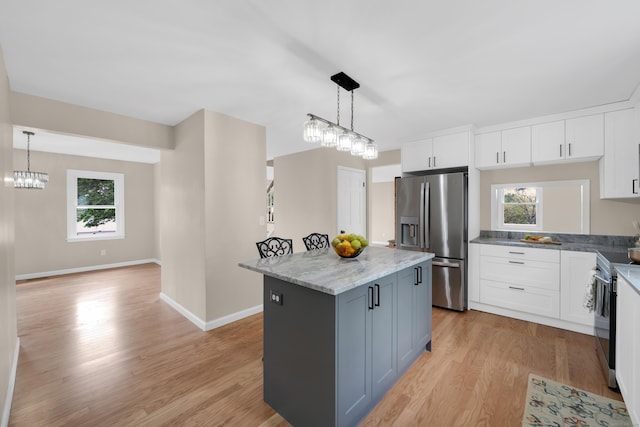63 Rita Dr, Bristol, CT 06010 - kitchen with stainless steel appliances, light wood-style flooring, white cabinets, a center island, and healthy amount of natural light