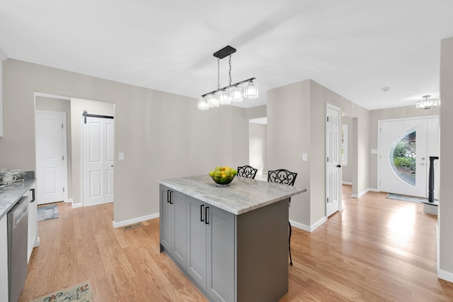 63 Rita Dr, Bristol, CT 06010 - kitchen featuring gray cabinets, light wood finished floors, a kitchen island, and a kitchen breakfast bar