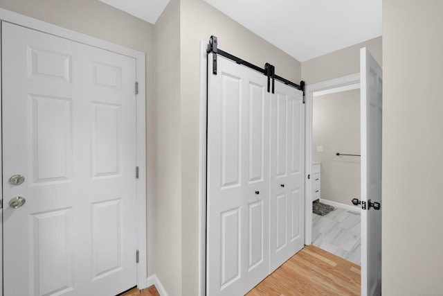 63 Rita Dr, Bristol, CT 06010 - hallway featuring a barn door, baseboards, and light wood-style flooring