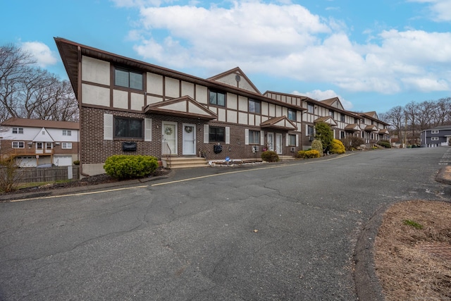 view of front facade featuring brick siding, a residential view, and stucco siding
