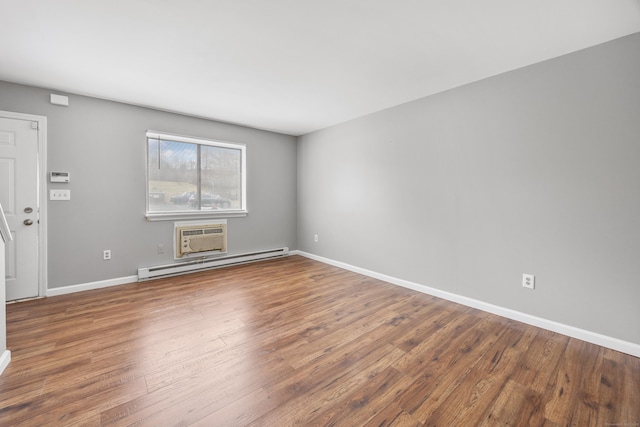 empty room featuring baseboards, wood finished floors, and a baseboard radiator