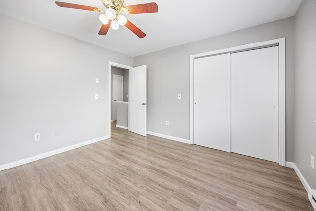 unfurnished bedroom featuring baseboards, a ceiling fan, wood finished floors, and a closet