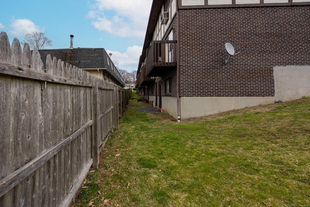 view of side of property featuring a lawn and fence