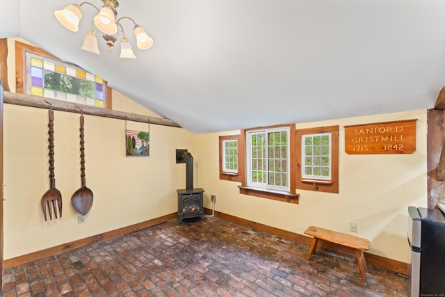 11 Glen Rd, Newtown, CT 06482 - unfurnished living room featuring baseboards, brick floors, vaulted ceiling, a wood stove, and a chandelier