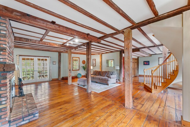 11 Glen Rd, Newtown, CT 06482 - living room with hardwood / wood-style floors, beamed ceiling, a fireplace, stairway, and french doors