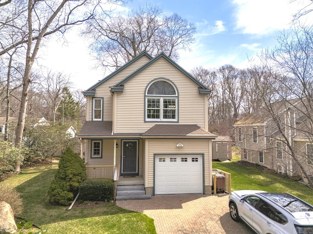 traditional home featuring roof with shingles, a front lawn, decorative driveway, and an attached garage