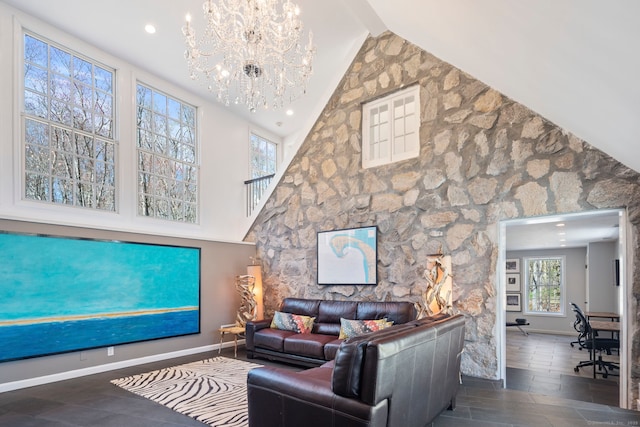 living room with wood finished floors, baseboards, high vaulted ceiling, and a chandelier