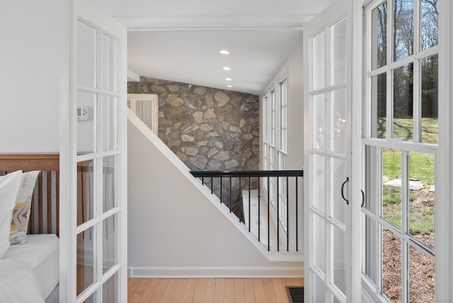 stairway with recessed lighting, plenty of natural light, visible vents, and wood finished floors