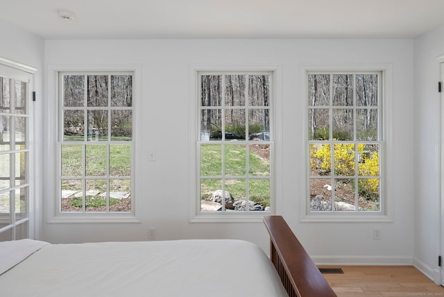 bedroom with light wood-type flooring, baseboards, and visible vents