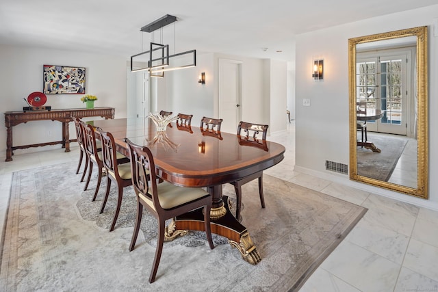 dining area featuring baseboards, visible vents, an inviting chandelier, and marble finish floor