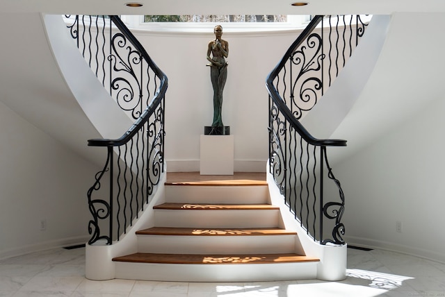 staircase featuring baseboards and marble finish floor