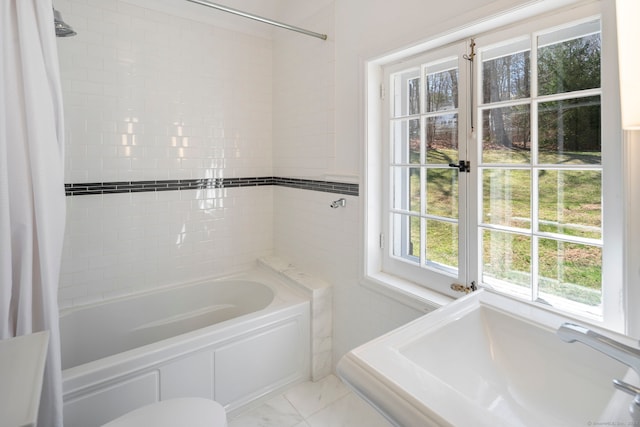 bathroom featuring shower / bath combo and marble finish floor
