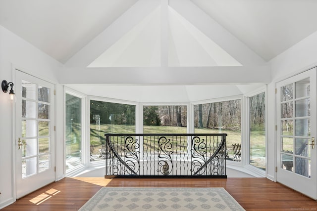 sunroom / solarium featuring lofted ceiling and wood finished floors