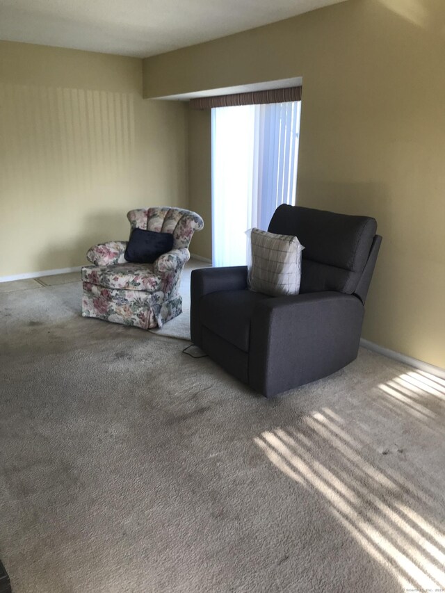 sitting room featuring baseboards and carpet