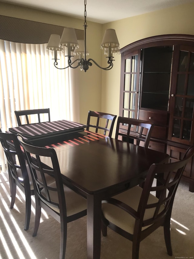 carpeted dining area featuring a chandelier