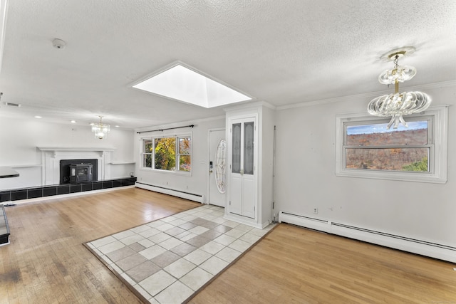 57 Bellevue Ter, Seymour, CT 06483 - unfurnished living room featuring a skylight, an inviting chandelier, wood finished floors, and baseboard heating