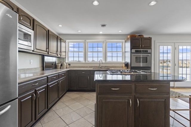 15 Buckingham Ave, Old Saybrook, CT 06475 - kitchen featuring stainless steel appliances, light tile patterned flooring, dark brown cabinetry, and recessed lighting